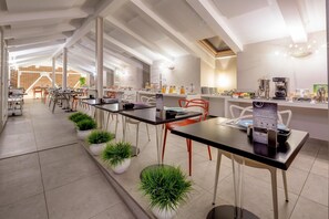 Enjoy a meal or drink at this café, featuring a long counter with seating options and a coffee machine.