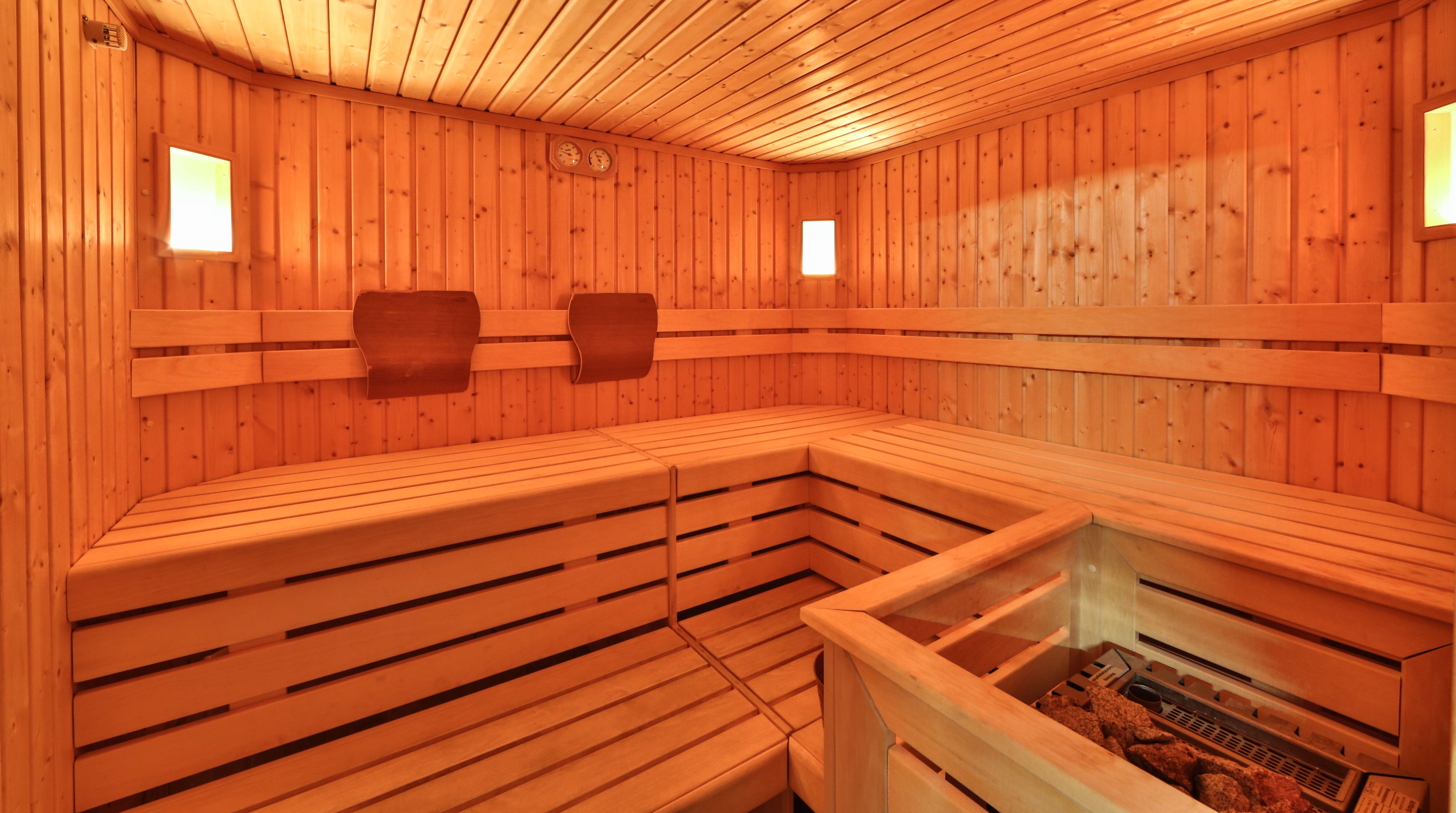 Una sauna con panche in legno e un divisorio in vetro.