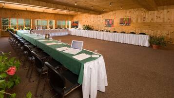 A conference room with long tables, chairs, and a laptop on one table.