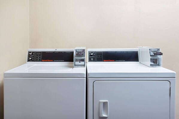 Two front-loading washing machines with digital displays and control panels. - Knights Inn Orlando (Orlando)