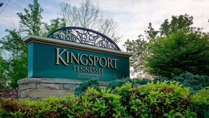 Een bord voor Kingsport, Tennessee, met een stenen voet en decoratief metaalwerk.