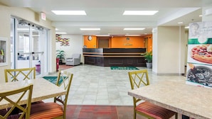 A hotel lobby with a reception desk, seating area, and a green mat on the floor. - Quality Inn Junction City - Near Fort Riley (Junction City)