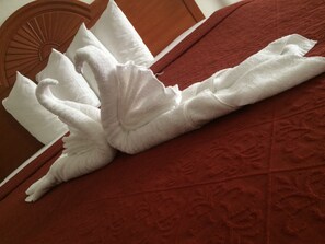 A bed with a red headboard and white pillows.