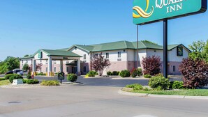 A Quality Inn hotel with a green and white exterior, a covered entrance, and a parking lot. - Quality Inn Junction City - Near Fort Riley (Junction City)