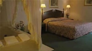 A hotel room with a bed, a nightstand, and a lamp. - Lakeview Inn (Willmar)