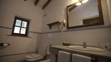Un baño con inodoro, lavabo y espejo.