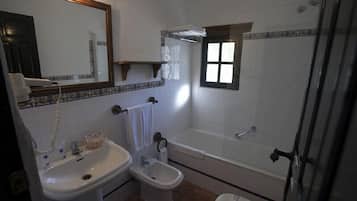Une salle de bain équipée d’un lavabo, d’un bidet, de toilettes et d’une baignoire.