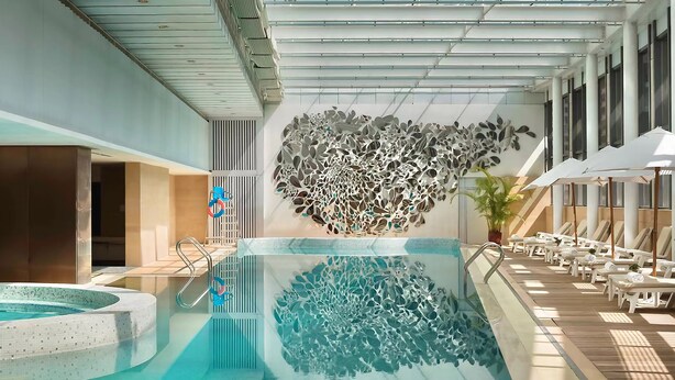 An indoor swimming pool with a modern design, including a unique wall art installation and sun loungers. - Marco Polo Parkside Beijing (Beijing)