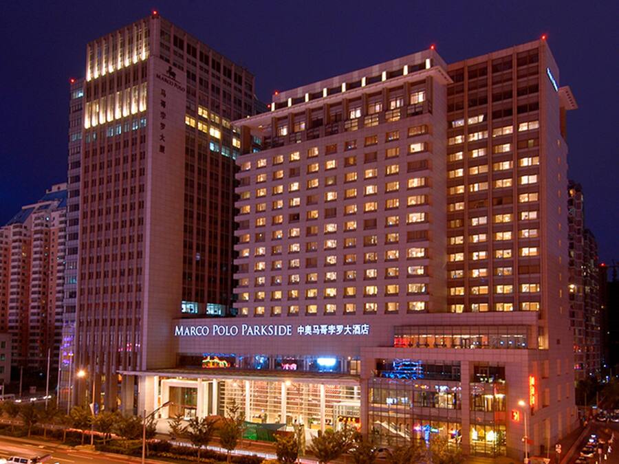 Un hotel de varios pisos con una entrada destacada y señalización.