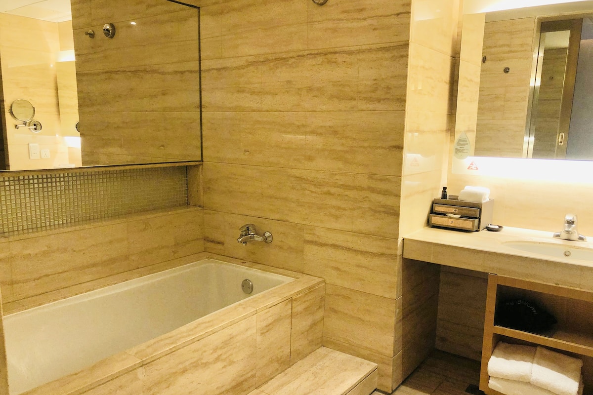A bathroom with a bathtub, a sink, and a mirror.