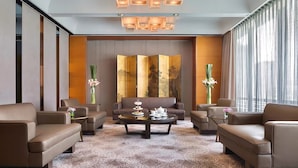 A modern hotel lobby with leather sofas, a central coffee table, and a decorative screen. - Marco Polo Parkside Beijing (Beijing)