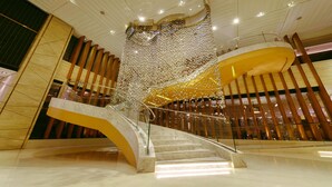 A modern interior with a marble staircase, a decorative glass installation, and wooden paneling. - Marco Polo Parkside Beijing (Beijing)