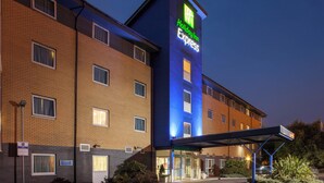 A Holiday Inn Express building with a brick facade, multiple windows, and a covered entrance area. - Holiday Inn Express Birmingham Star City by IHG (Birmingham)