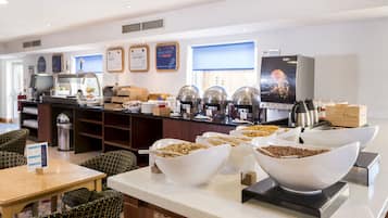 Un'area buffet con diverse opzioni gastronomiche, un angolo caffè e posti a sedere.