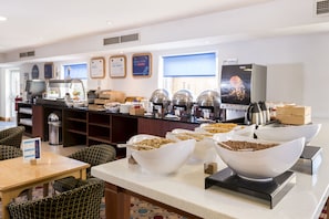 A buffet area with various food options, a coffee station, and seating arrangements. - Holiday Inn Express Birmingham Star City by IHG (Birmingham)