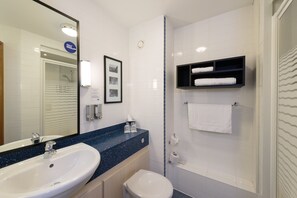 A modern bathroom with a white sink, a toilet, and a shower. There is a framed picture on the wall and a towel rack with towels. - Holiday Inn Express Birmingham Star City by IHG (Birmingham)