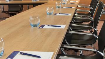 Une salle de conférence équipée d’une longue table, de chaises et de verres.
