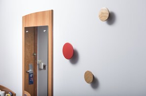 A room with a wooden door, a mirror, and three wall-mounted round objects. - Holiday Inn Express Birmingham Star City by IHG (Birmingham)