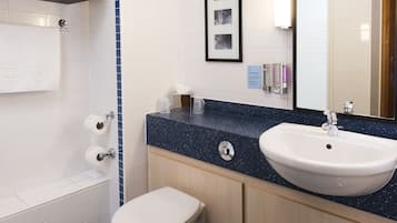 A bathroom with a white toilet, a sink with a mirror, and a towel rack.
