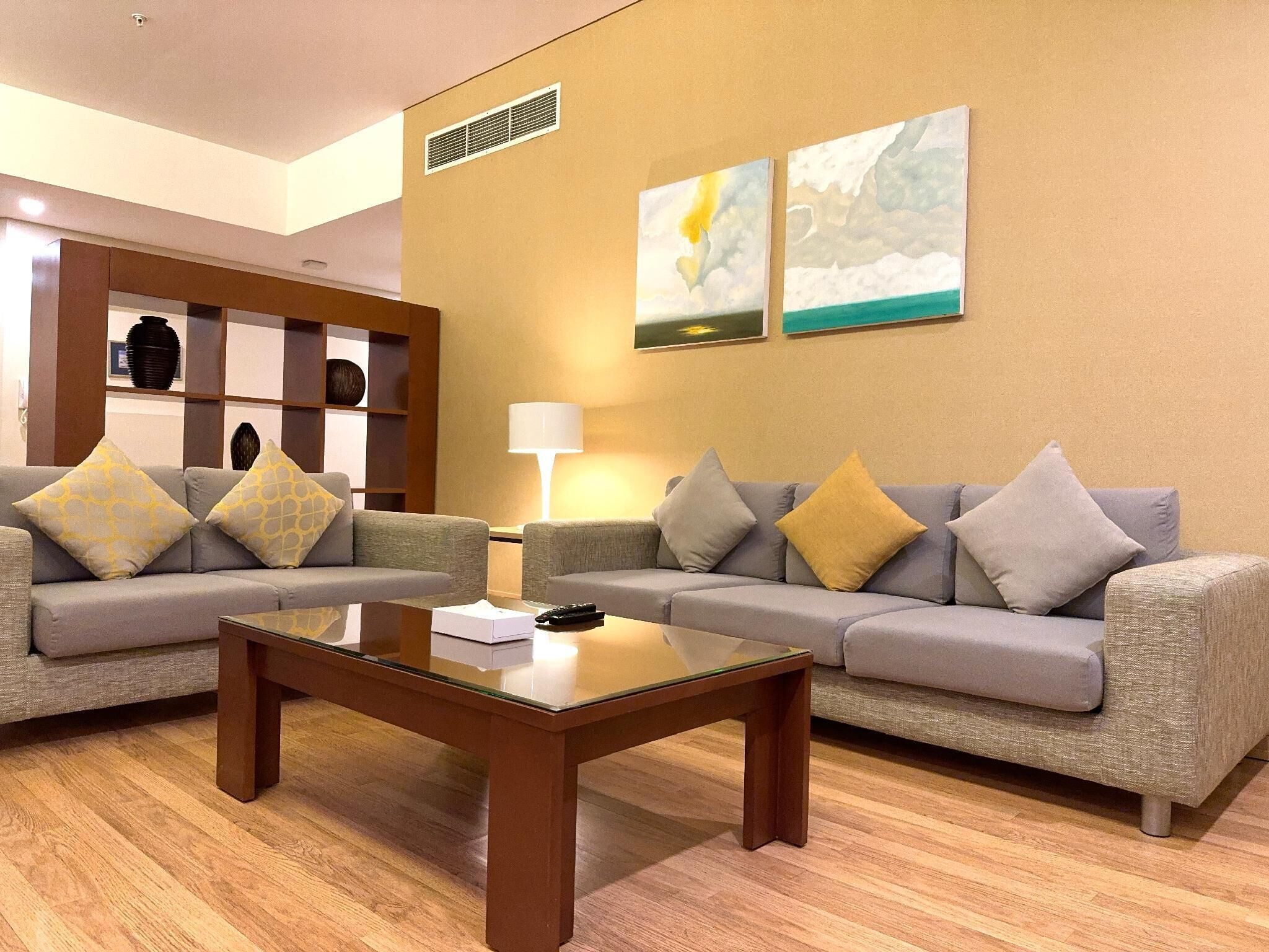 A modern living room with two sofas, a coffee table, and artwork on the wall.
