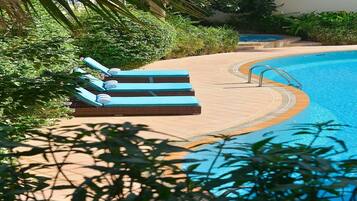 A poolside area with lounge chairs and a pool.
