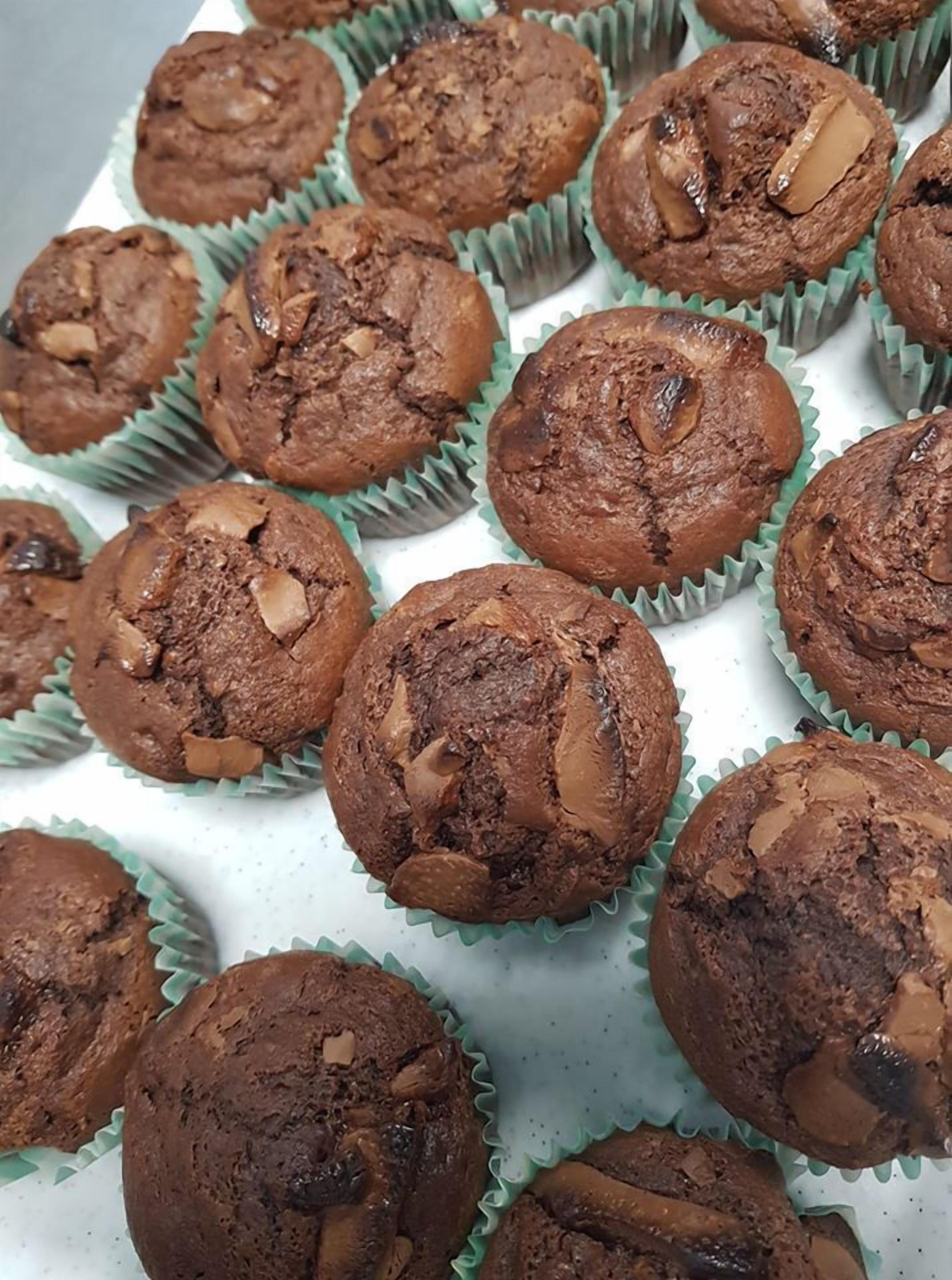 En bricka med chokladmuffins, där man tydligt kan se bitar av nötter och choklad.
