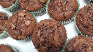 En bricka med chokladmuffins, där man tydligt kan se bitar av nötter och choklad.