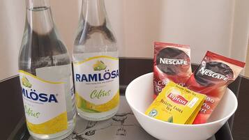 Two bottles of Ramlosa citrus drink, a bowl of Nescafe coffee, and Lipton tea on a tray.