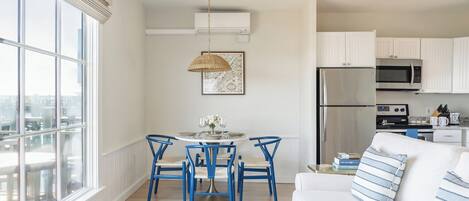 A modern kitchen with white cabinets, a stainless steel refrigerator, and a microwave.