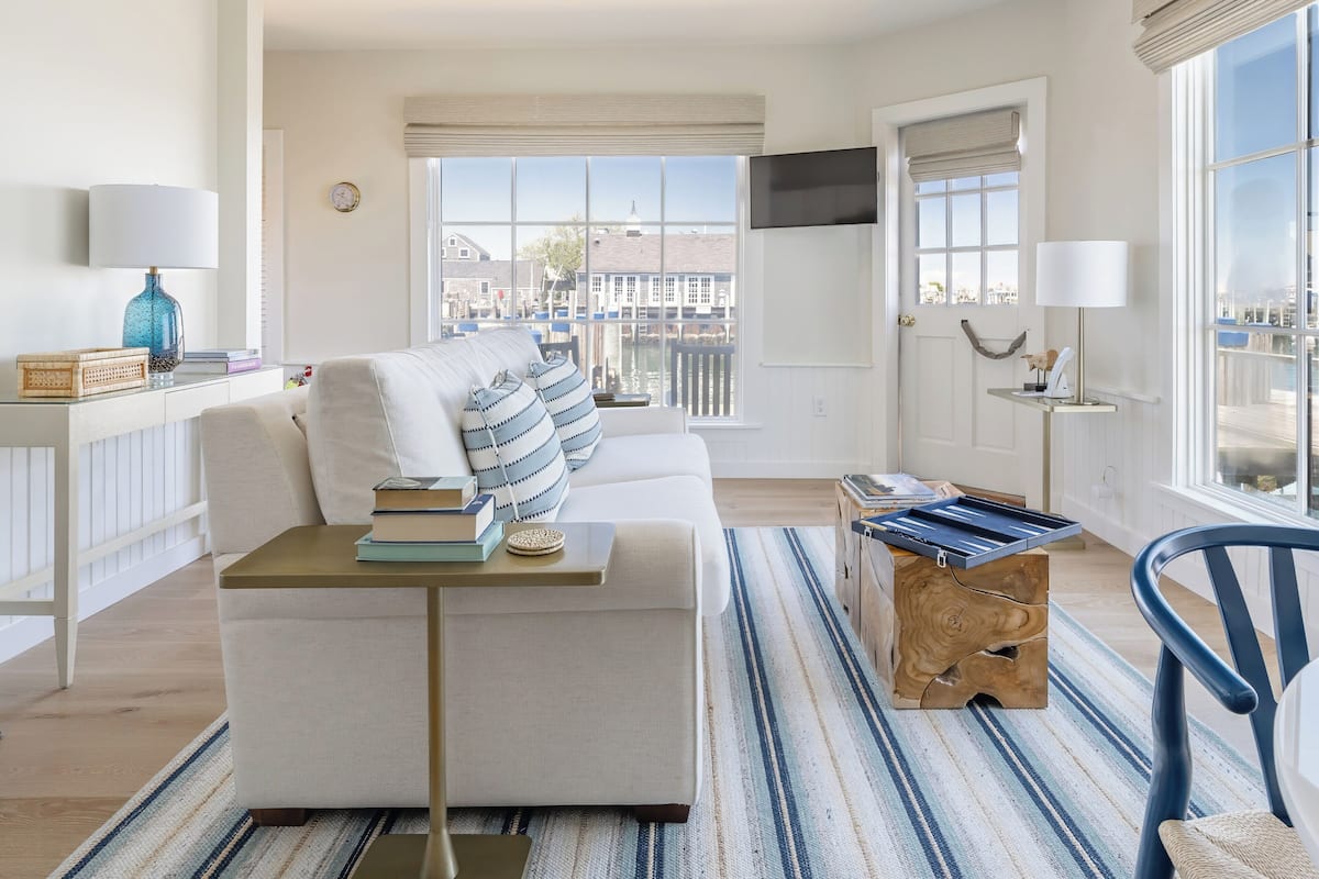 A modern living room with a sofa, a coffee table, and a view of a canal.