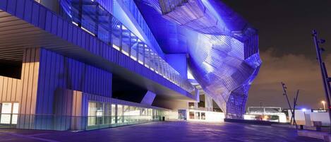 Um edifício moderno com um design angular único e iluminação azul iluminada.