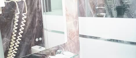 Un baño con estante de vidrio, espejo y zona de ducha.