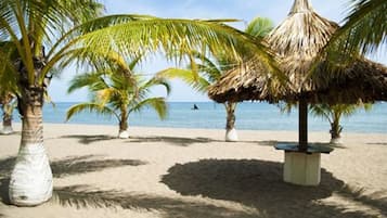 Trên bãi biển, ghế dài tắm nắng, dù trên bãi biển, khăn tắm biển