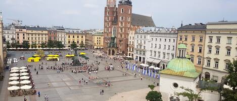 A spacious public square with historical buildings, a prominent church tower, and a green-domed structure.