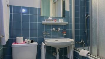 A bathroom with a toilet, sink, and shower.