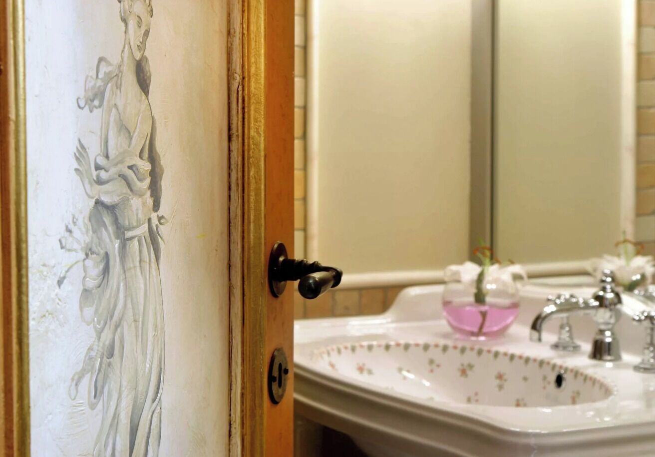 Un baño con lavabo, espejo y una puerta con cerradura.