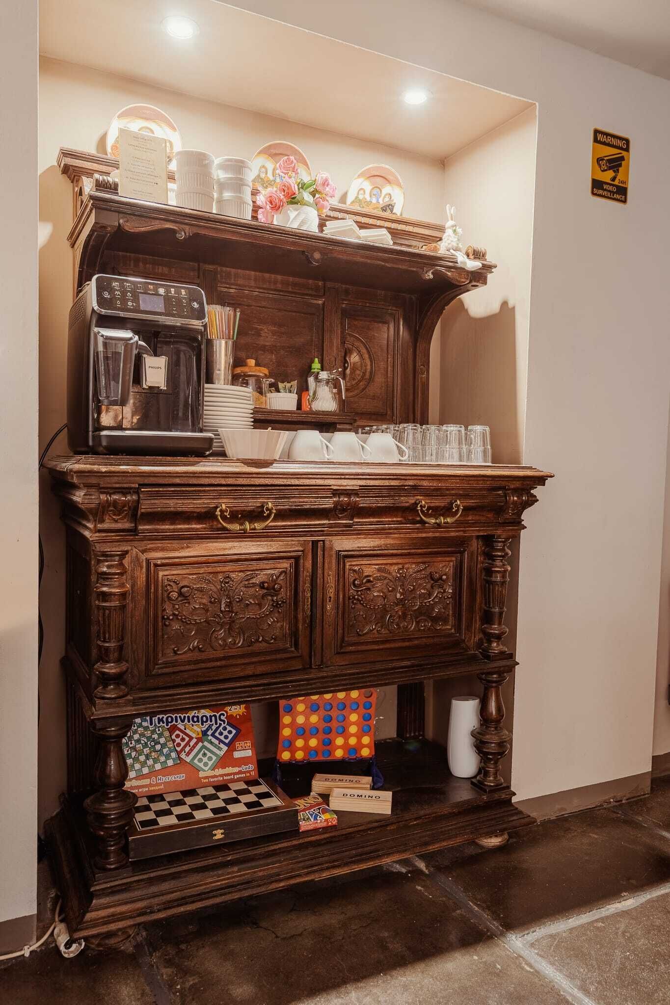 A wooden bar area with a coffee machine, cups, and a board game.