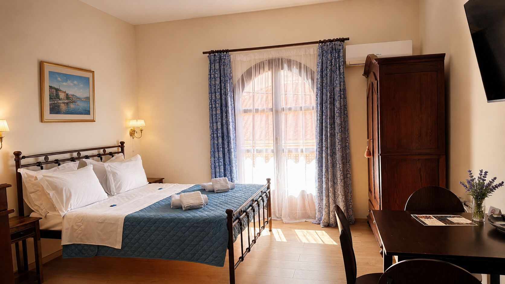 A hotel room with a bed, bedside table, lamp, window with curtains, and a wooden cabinet.