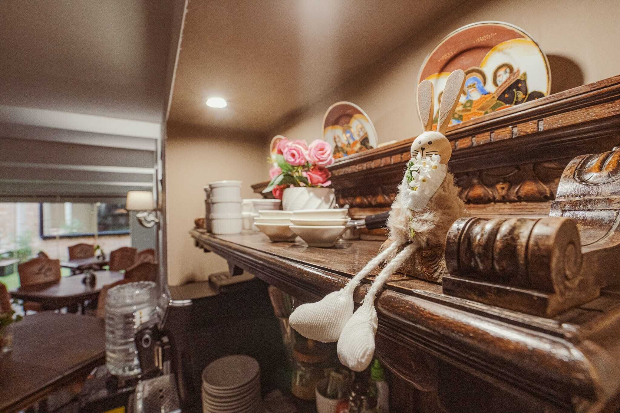 A dining area with a wooden table, chairs, a water dispenser, and a decorative item resembling a bird.