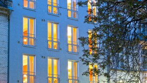 Un hotel de varios pisos con amplias ventanas y balcones, que muestra un cartel que dice 'hotel urbano'.