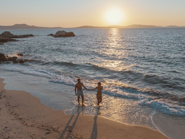 Una playa cerca, sillas reclinables de playa, sombrillas
