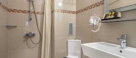 A bathroom with a shower, toilet, and sink.