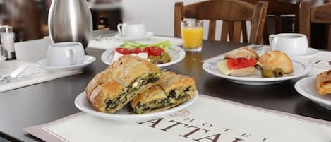 En morgenmadsopsætning med croissanter, en salat og en kaffedrik.