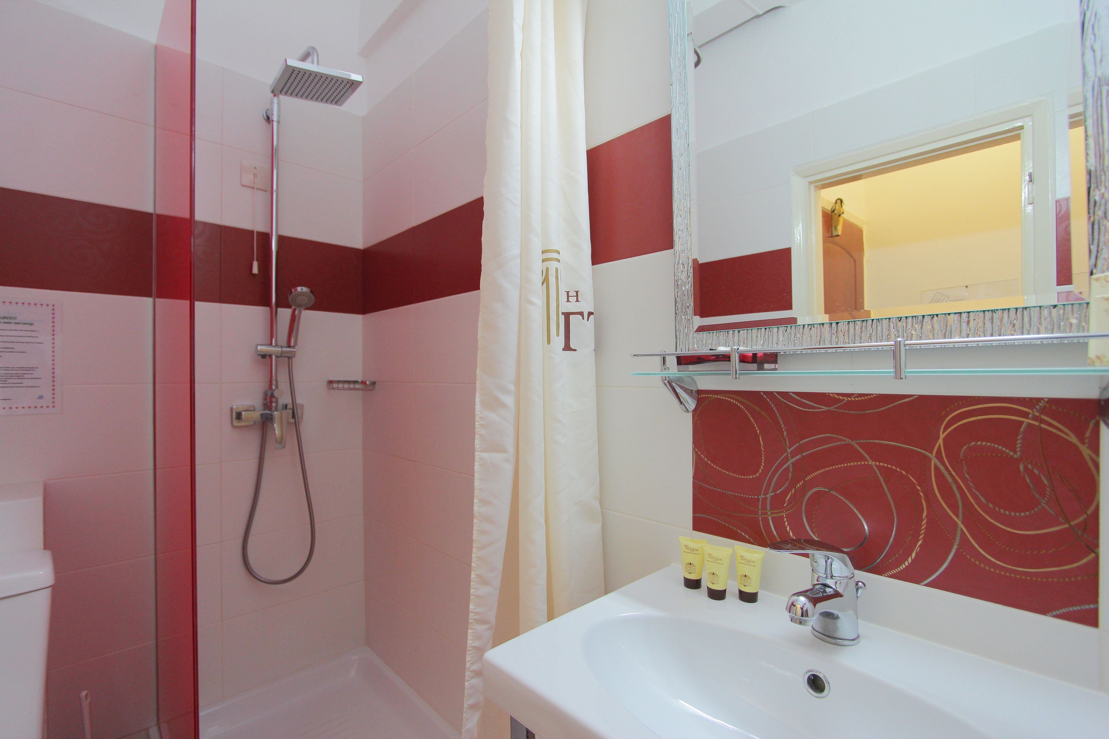 A bathroom with a shower, a sink, and a mirror.