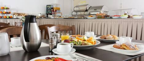 Un bufé de desayuno con diversas opciones de comida y bebidas.