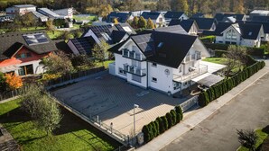 A residential area with houses featuring solar panels, a paved driveway, and a clear view of the surrounding landscape. - Penzion Kovac (Radovljica)