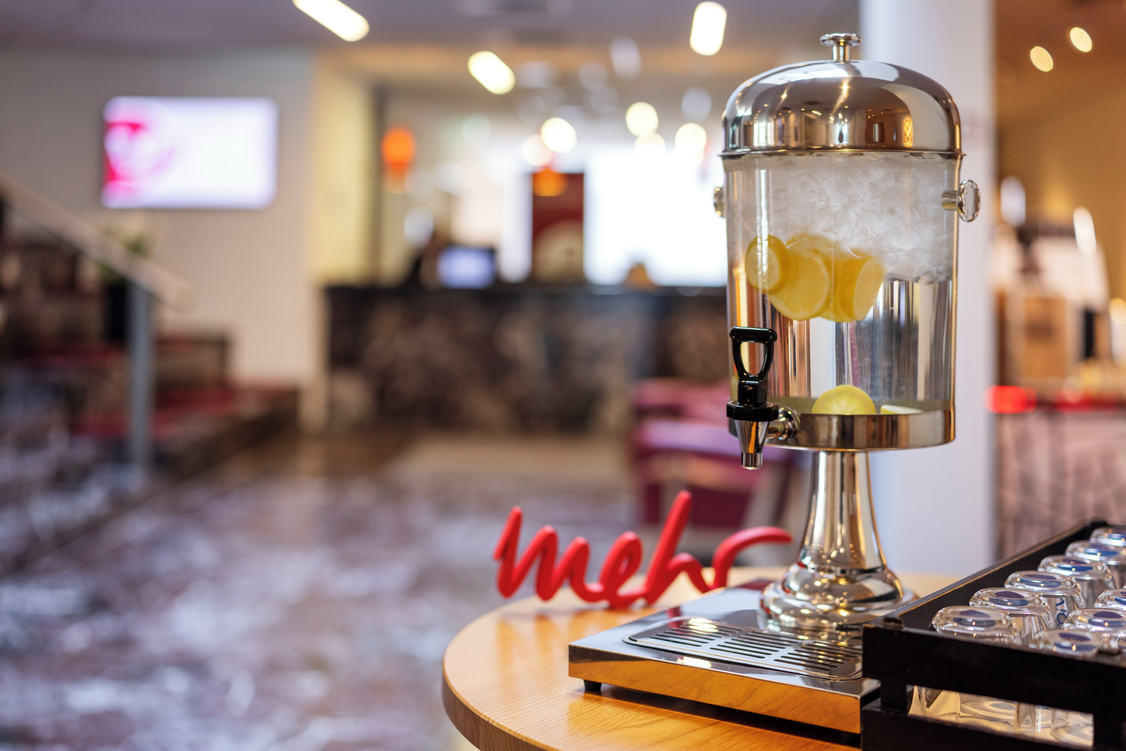 Una zona de bar con un shaker de cócteles, hielo y limones.