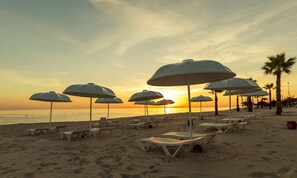 Sabbia bianca, lettini da mare, ombrelloni, un bar sulla spiaggia