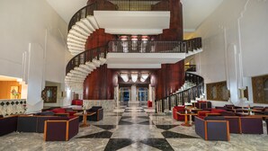 A grand lobby with a marble floor, a double spiral staircase, and modern seating areas. - El Mouradi Port El Kantaoui (Port El Kantaoui)