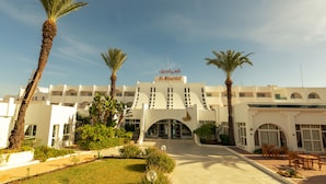 A hotel with a central entrance, palm trees, and a clear sky. - El Mouradi Port El Kantaoui (Port El Kantaoui)